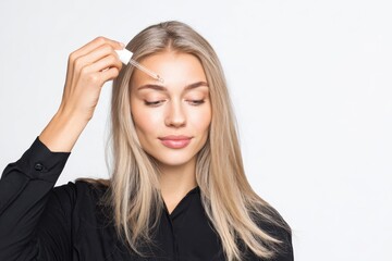 Fototapeta premium Young woman applying serum on her face. Caucasian 20s girl holding dropper skin care product. Female applies essential oil with oily pipette. Advertising facial care cosmetics. Health, youth. Serums