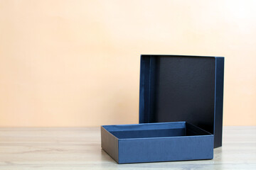 Open empty black gift box on wooden table