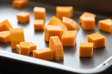 chopped bite size butternut squash pieces on tray raw and fresh close up