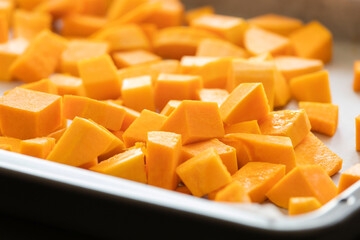 chopped bite size butternut squash pieces on tray raw and fresh close up