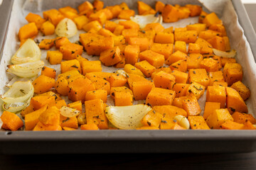 tray with roasted pumpkin butternut squash onion and garlic close up