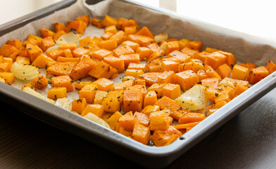 tray with roasted pumpkin butternut squash onion and garlic close up