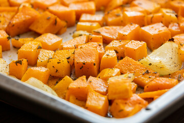 tray with roasted pumpkin butternut squash onion and garlic close up