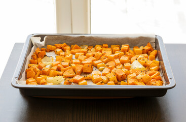 tray with roasted pumpkin butternut squash onion and garlic close up