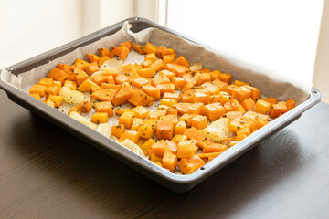 tray with roasted pumpkin butternut squash onion and garlic close up