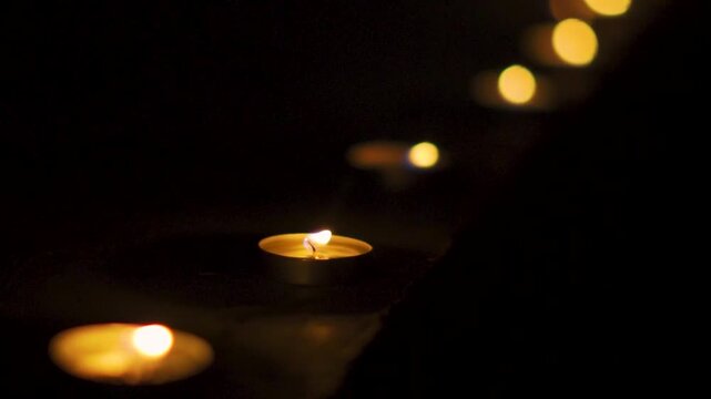 Close up shot of illuminating Diyas in row. Lit Diya in dark night background. Happy Diwali background. Diwali decoration in Indian home. Diwali is festival of lights and happiness
