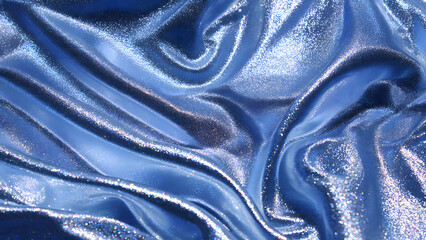 Abstract flowing blue metallic fabric with shimmering texture and light reflections
