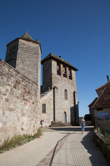 Touriste marchant vers l'église de Curemonte plus veau village de France (Corrèze)