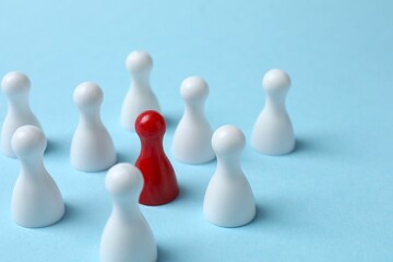 The concept of unity. A group of colored pawns on a blue table.