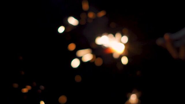 Defocused shot of sparker burning in dark background. Diwali celebration background. Fireworks during Diwali festival celebration. New year, Christmas and Diwali concept. 