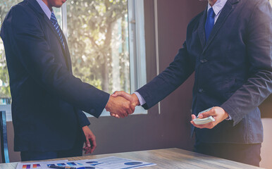 Businessman handshake at business meeting after negotiations with business partners and making investment. Selected focus