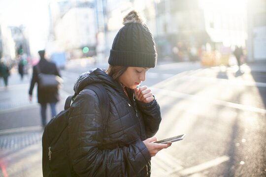 Person using smartphone for navigation in city with magical morning light