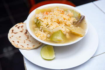 Authentic Bowl of Chicken Soup with Rice and Tortilla Dish