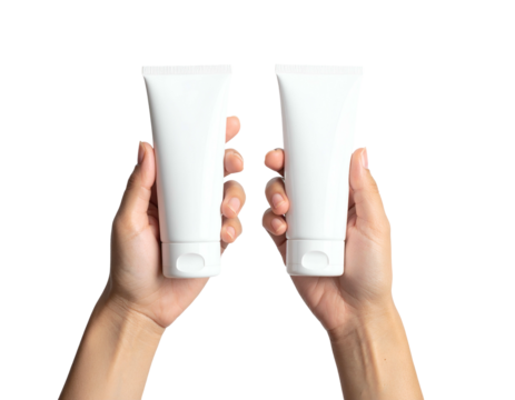 Two white cosmetic tubes held upright by two hands against a stark black background - Powered by Adobe