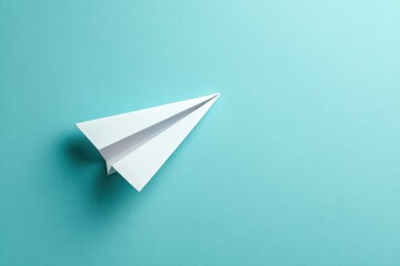 White Paper Airplane on Aqua Background: Symbol of Flight and Imagination