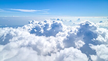 Fototapeta premium Soaring above a vast ocean of fluffy white clouds under a brilliant clear blue sky, inspiring freedom and boundless possibility for travel and dreams.