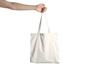 A human hand holding a plain, white tote bag, isolated on a black background