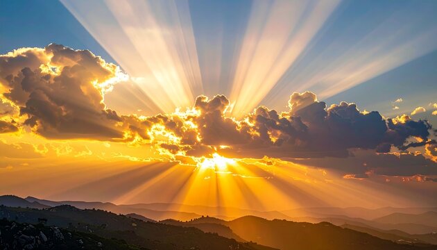 Golden sunbeams pierce dramatic clouds over layered mountain ranges at dawn, creating a breathtaking, hopeful natural spectacle for serene backdrops and inspirational use