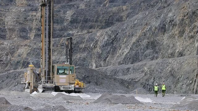 Drill rigs machine for drilling rock for explosives installation with team Engineers surveyor, quarry ore mining.