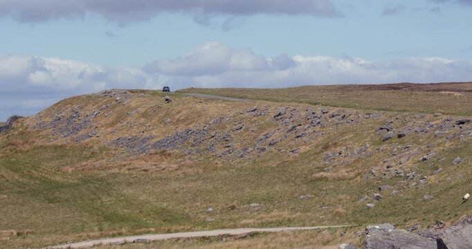 wide shot looking north up Kaber fell, and Bowes moor with a car going up on the Regional RTE 71 road. At the pennines