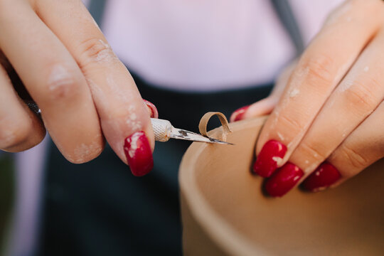 Pottery carving close-up. Artistry of carving clay pottery is shown in detail. Process of sculpting clay bowls blends precision with creativity, highlighting craftsmanship and ceramic traditions.