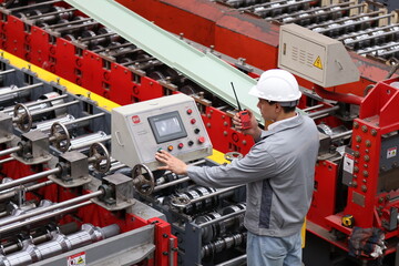 Industrial Engineer in Hard Hats Work at the Heavy Industry Metal Sheet Manufacturing Factory. Factory worker indoors in metal sheet factory. Man working in an industrial factory. 
