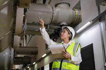 inspecting high-voltage gas-insulated switchgear (GIS), Female engineer in safety helmet,...