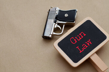 A semi-automatic pistol overlaid with the words "Gun Law" in red, creating a powerful and neutral icon for the ongoing debate over firearm regulations.