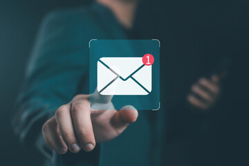 Businessman touching new email notification icon on virtual screen, concept of digital communication, online marketing, message alert, technology connection, and smart business network.
