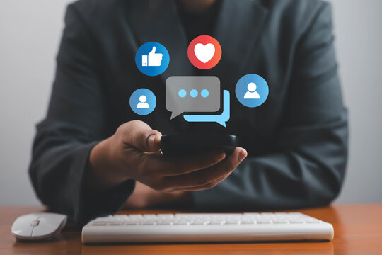 Businessman using smartphone with social media icons, concept of online communication, digital marketing, customer engagement, social interaction, and business networking. - Powered by Adobe