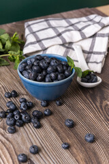 Perfectly round blueberries on a black granite background and a clear rock crystal spoon