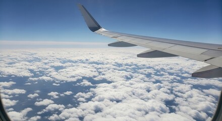 Fototapeta premium Airplane window view above fluffy clouds and blue sky scenic aerial perspective