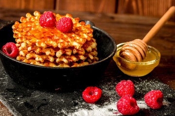 waffles with raspberries on wooden background