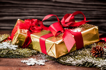 gifts boxes with fir branches on wooden background close up