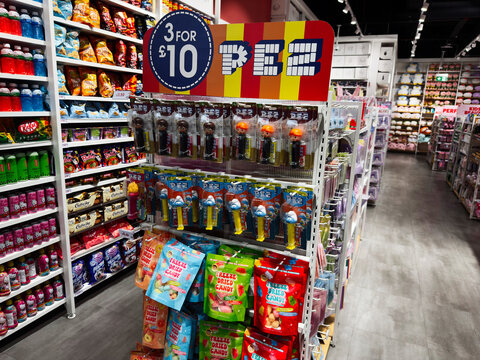 Bright discount candy display in a colorful Miniso store aisle with PEZ dispensers