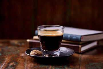 Coffee in glass cup on rustic wooden background. Soft focus. 