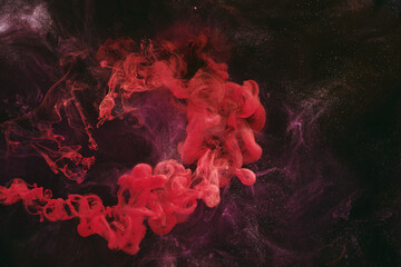 Abstract colorful smoke, dark background. Moving flow of red paints, fluid art
