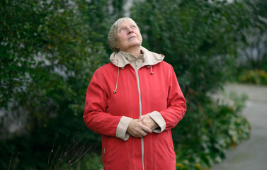 Older woman in red jacket enjoying nature.