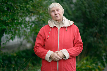 Older woman in red jacket enjoying nature.