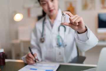 Doctor holding medical vial examining data