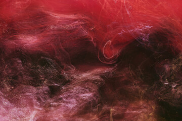 Abstract colorful smoke, dark background. Moving flow of red paints, fluid art
