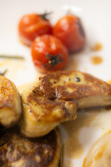 Elegant Gourmet Dish: Succulent Seared Foie Gras with Roasted Tomato and Thyme, Served with a Rich, Exclusive Specialty Sauce on a White Plate