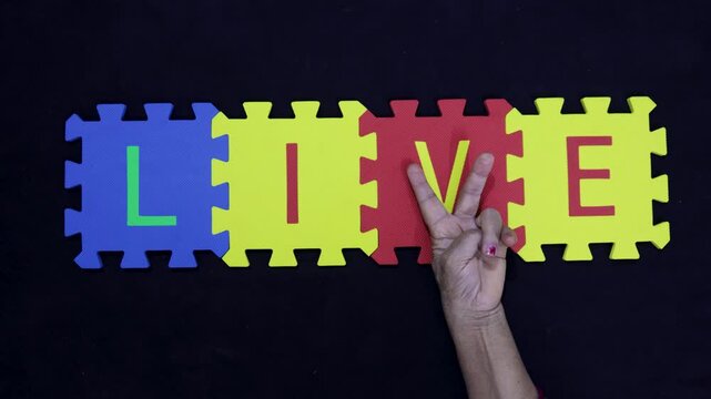 senior hand making v sign for word live over dark background