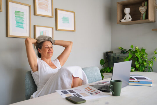 Relaxed woman enjoying success and tranquility in home office