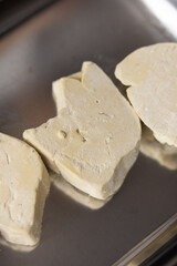Close-up of Raw, Uncooked Foie Gras Lobe or Goose Liver on a Cutting Board in a Professional or Gourmet Kitchen, Ready for Culinary Preparation