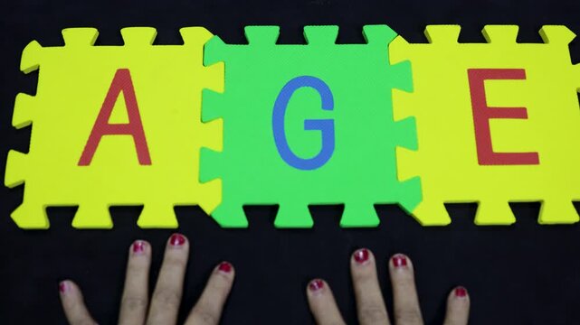 concept of aging or elder years presented with wrinkled hands and letters AGE