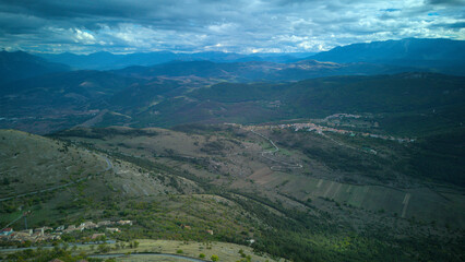 Drone aerial view of Monte Calascio, Abruzzo, featuring the medieval Rocca fortress and spectacular surrounding mountain landscapes