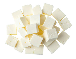 Overhead view of many freshly cubed, pale yellow dairy product portions on a dark background