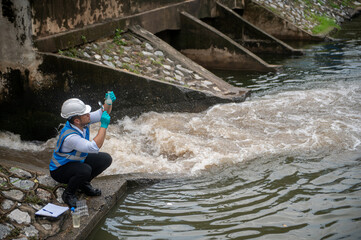 Wastewater treatment worker is collecting samples of water from a public well