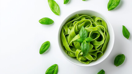Obraz premium Bowl of green tagliatelle pasta with fresh basil leaves on a white background. 